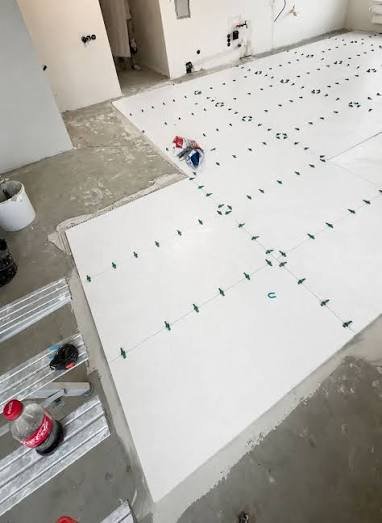 Pose précise de grands carreaux blancs au sol